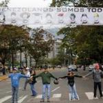 Demonstrators join hands to block the highway at Altamira neighborhood in Caracas, Venezuela.